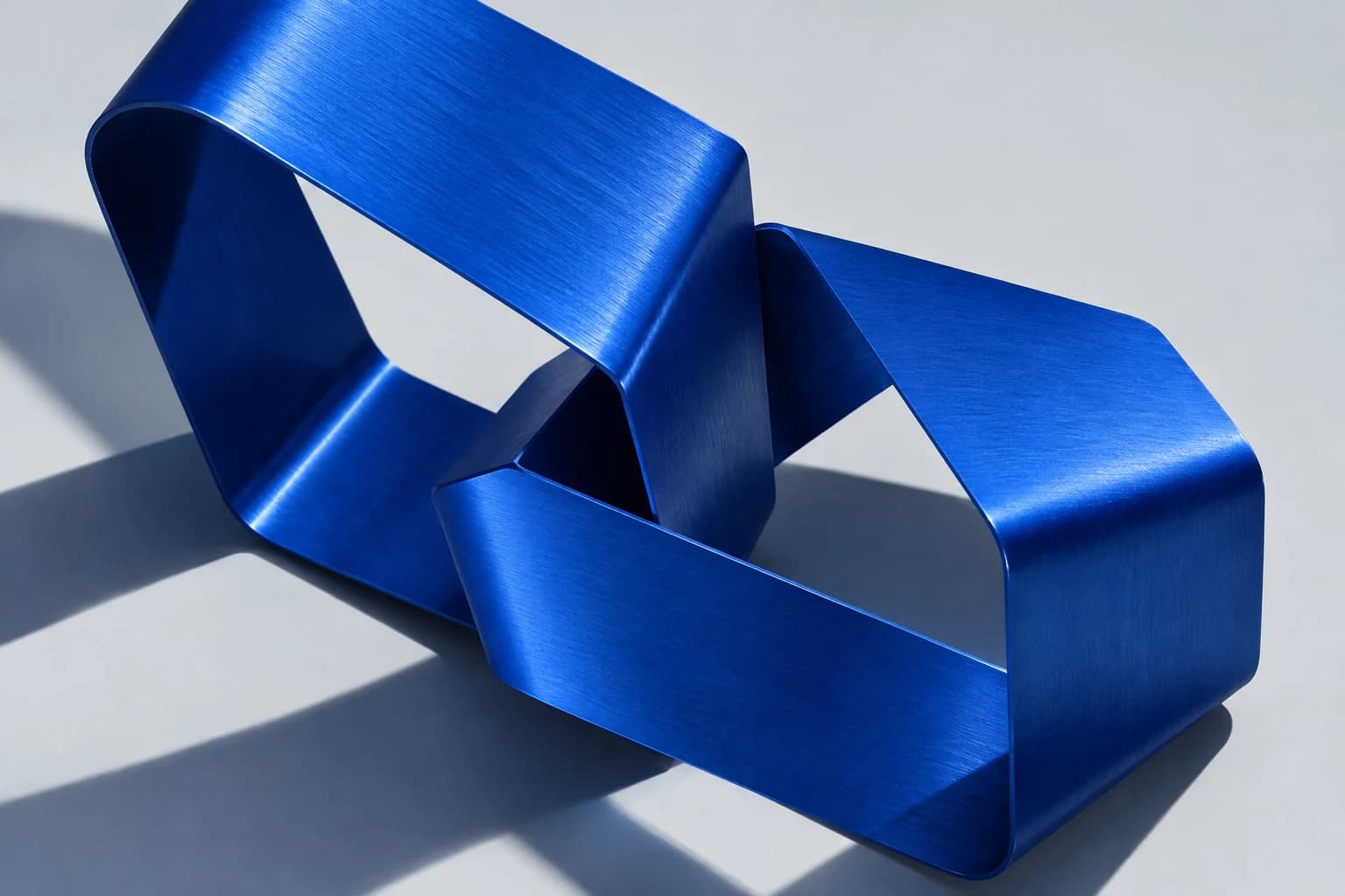 Two interlocking cobalt blue folded forms, a sculptural study of connection